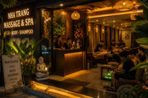 Spa entrance and reception with warm lighting, massage clients on beds inside a dimly lit, tropical-themed parlor signboard visible outside.