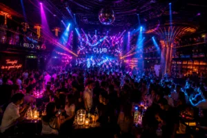 Crowded nightclub with a glowing stage, a large disco ball, and colorful lasers lighting the dance floor.